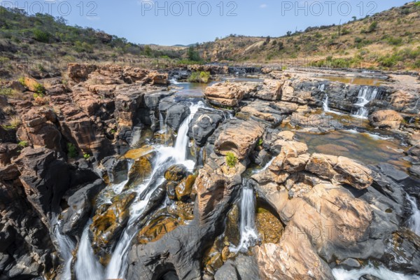 Waterfall on orange-coloured rock cliffs, long exposure, Blyde River, Bourke's Luck Potholes,