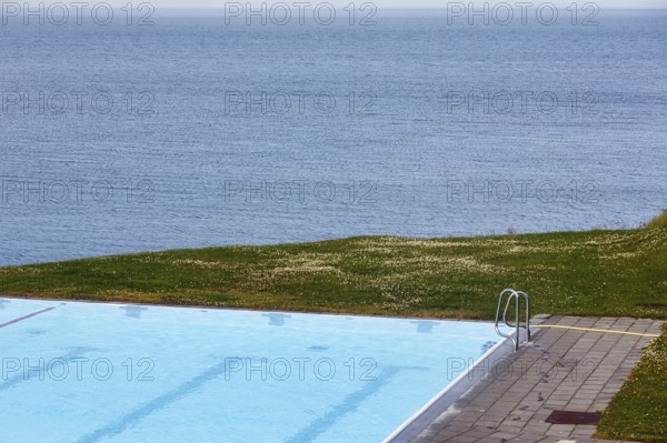 View from above of swimming pool by the sea, thermal bath, heated outdoor pool in Hofsos at the
