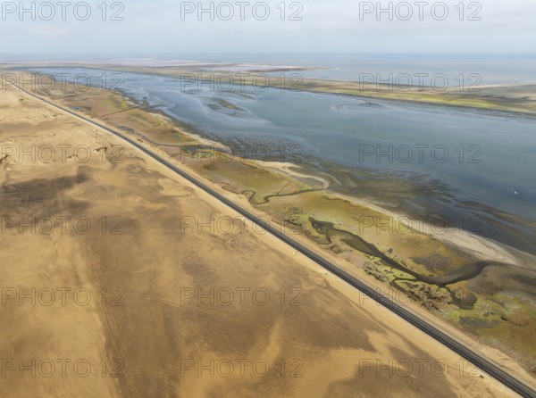 The Walvis Bay Lagoon between Namib Desert and Atlantic Ocean. At low tide with scattered flamingos