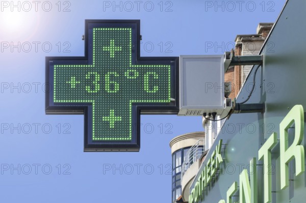 Thermometer in green pharmacy screen sign displays extremely hot temperature of 36 degrees Celsius