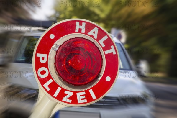 (Photomontage) Symbolic image of a police check: close-up of a police trowel labelled HALT POLIZEI