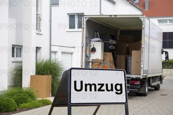 (Photomontage) Relocation symbolic image: lorry in front of a residential building, in front of it