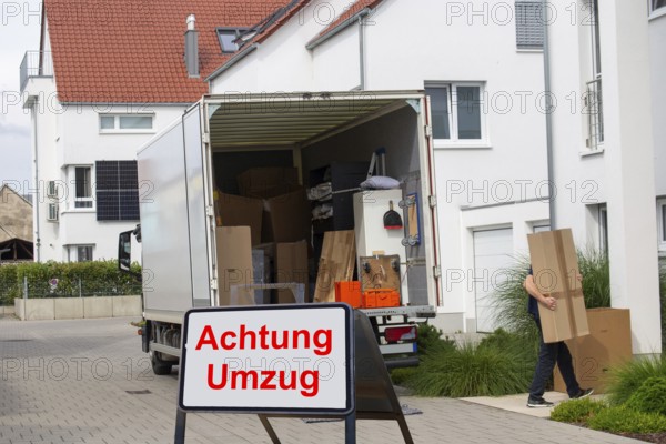 (Photomontage) Relocation Symbolic image: lorry in front of a residential building, in front of it