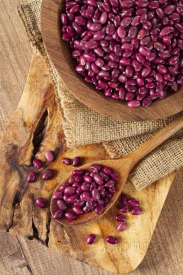 Red beans, laid out in a wooden bowl, on a chopping board, rustic style, covered with burlap, top