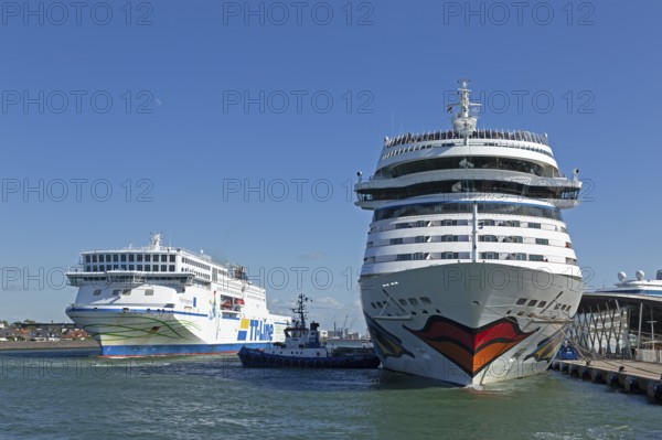 Cruise ship AIDA nova is pushed against the quay wall by tugboats, TT-Line ferry Nils Holgersson,