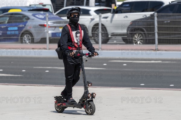 Man with electric scooter, Abu Dhabi, United Arab Emirates