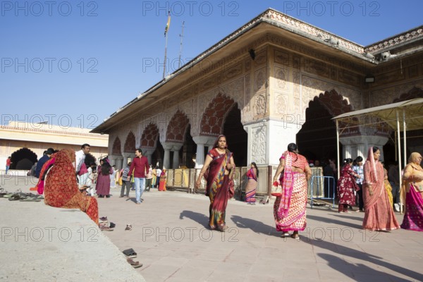 Colourfully dressed Indians at the Govind Dev Ji Hindu temple in the old town, Jaipur, Rajasthan,