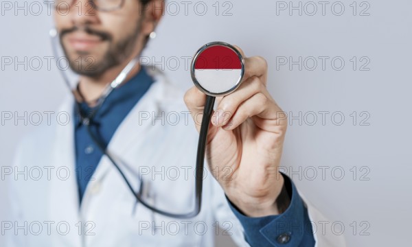 Doctor holding stethoscope with Monaco flag. Monaco health and care concept, Monaco flag on