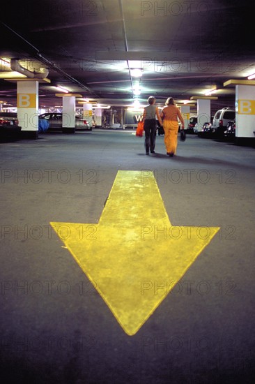 Yellow directional arrow in a high-rise car park, New York City, USA
