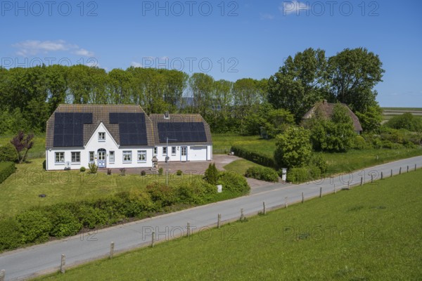 Typical Frisian house, photovoltaics on the roof, landscape on the dyke, Tammensiel, Pellworm