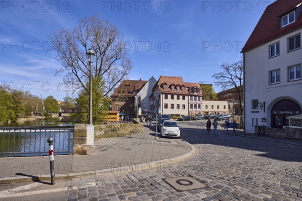 General architecture, street, cobblestone pavement, parking lane with vehicles, metal railing,