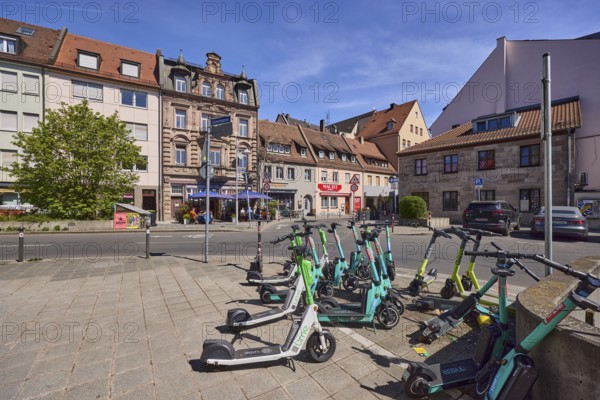E-scooter in the city, problem, traffic problem, pavement, pavement slabs, tree, blue sky,