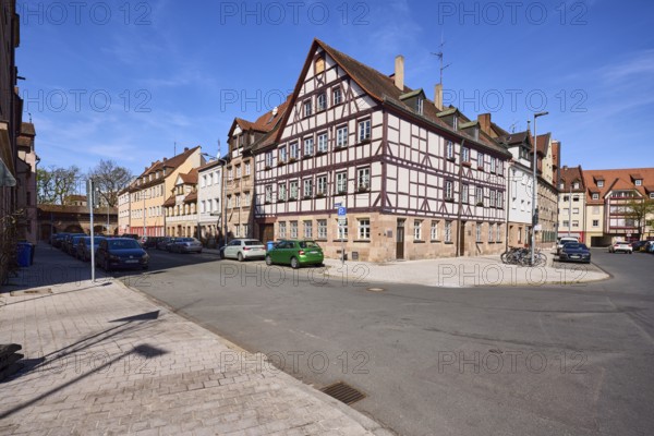 Old town, half-timbered house, general architecture, lantern, parking lane with vehicles, blue sky,