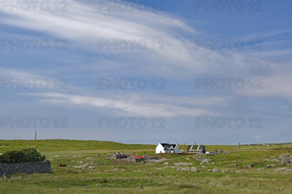 Rural area with a remote farmhouse under a wide blue sky, Outer Hebrides, South Uist, Scotland,