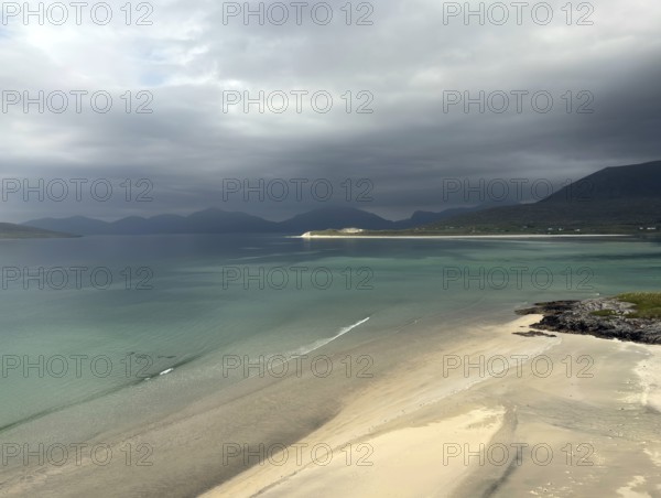 Stormy coastal view with grey sky and calm sea to the shore of a wide bay, Outer Hebrides, Isle of