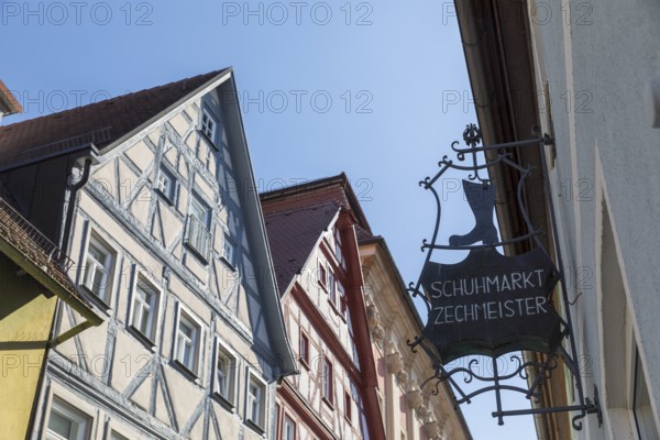 Advertising sign of the Zechmeister shoe market, behind it the half-timbered gables of the old