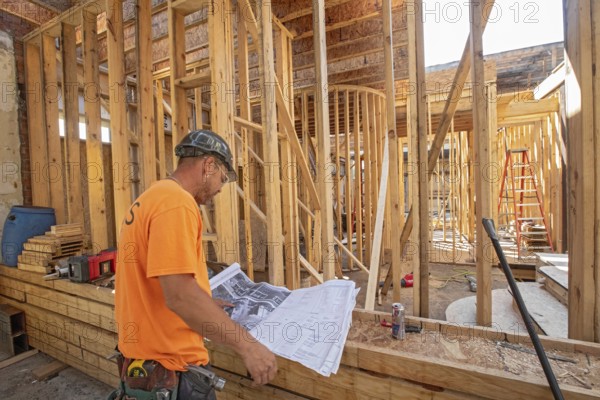 Detroit, Michigan - Jay Newcomb III looks over architectural plans as workers rehab a long-vacant
