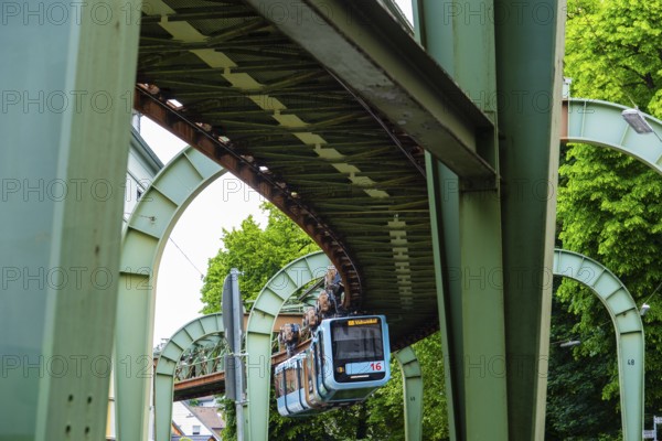 The Wuppertal suspension railway runs through Vohwinkel in front of buildings from the Wilhelminian