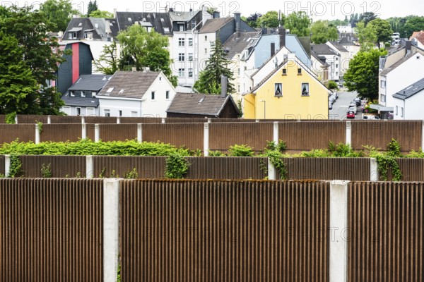 A row of noise barriers in front of a residential area at the Sonnborn junction in Wuppertal,
