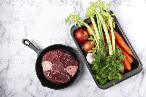 Sknuckle on the bone, raw meat for ossobuco, in a cast-iron pan, baking sheet with vegetables, top
