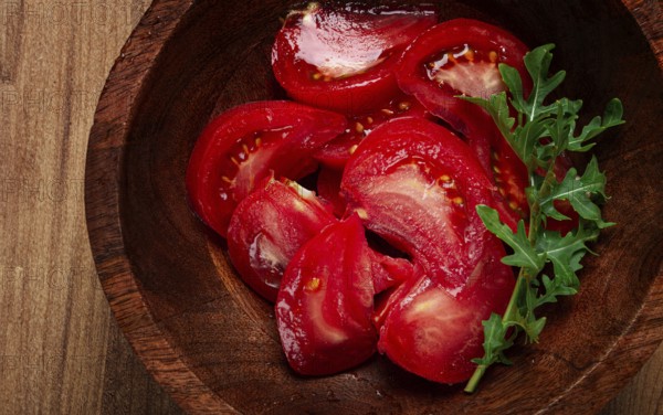 Sliced tomato, on a wooden plate, tomato salad, food background, no people