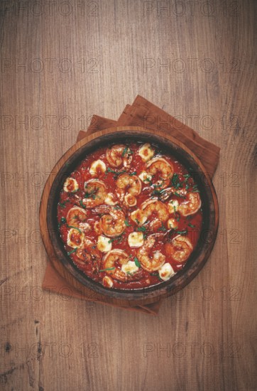 Saganaki with shrimp, in a clay pan, Greek dish, shrimp in tomato sauce, feta cheese, homemade, no