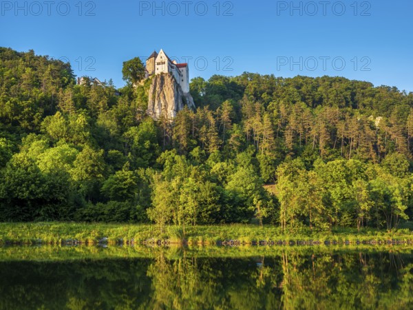 Prunn Castle on a steep cliff above the AltmÃ¼hl Valley in the evening light, reflection in the