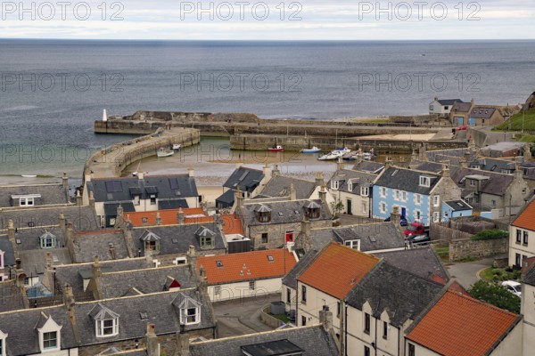 Harbour town with view of rooftops and boats in a small harbour basin by the sea, Portsoy,