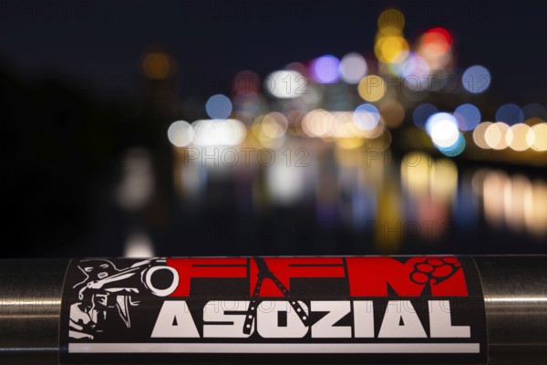 The lights of Frankfurt's banking skyline are blurred in the background. In front of it, the
