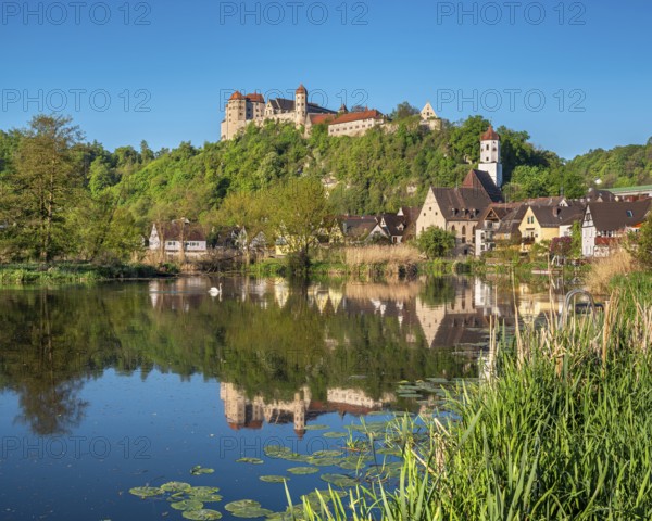 Castle and old town with St Barbara's Church and synagogue reflected in the River Wörnitz, Harburg,
