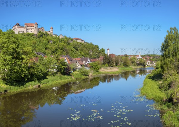 View over the river Wörnitz with water lilies to the castle and the old town with the churches of