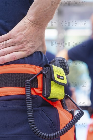Close-up of fire brigade equipment with radio and firefighter in uniform, fire brigade exercise for