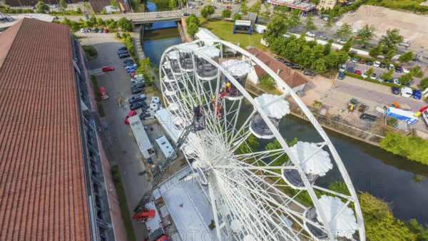 View from above of a Ferris wheel next to a river and buildings, fire brigade exercise for gondola