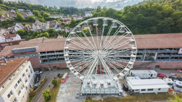 Urban landscape with a central Ferris wheel surrounded by trees, fire brigade exercise for gondola