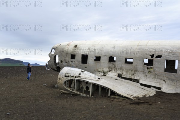Tourist photographing aircraft wreckage, US Navy Douglas DC-3 transport plane, Sander, volcanic