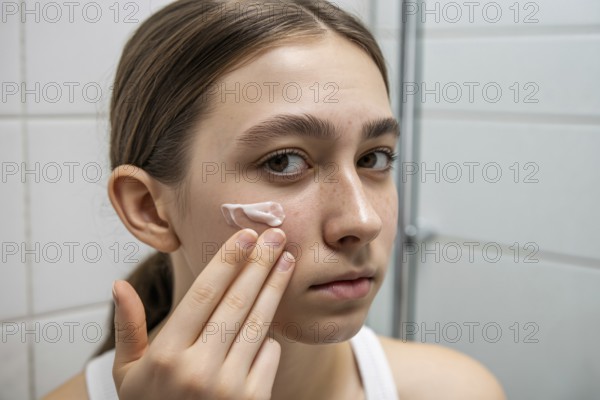 Teenager applying skin cream in bathroom. Honest daily skincare and self-care routine. Generative