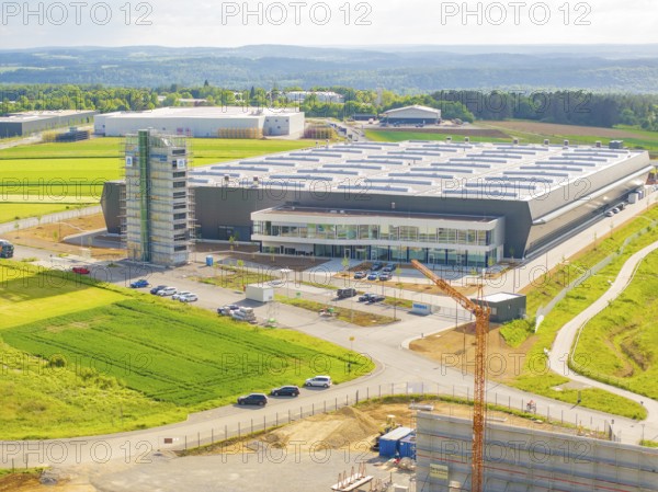 Large modern warehouse in the middle of green fields under a cloudy sky, industrial area, Nagold, I