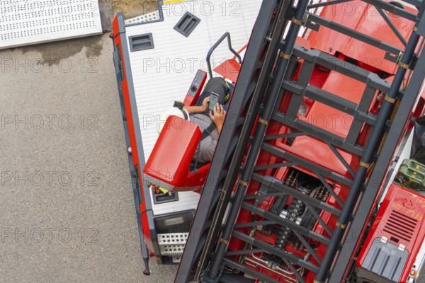 A firefighter operates the controls of a large mobile crane, fire brigade exercise for gondola