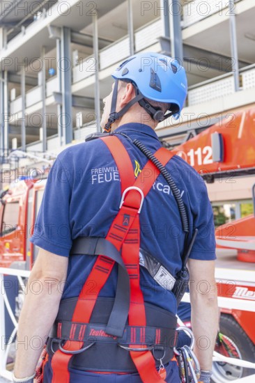Fire brigade employee with safety equipment looking at a vehicle, fire brigade exercise for gondola