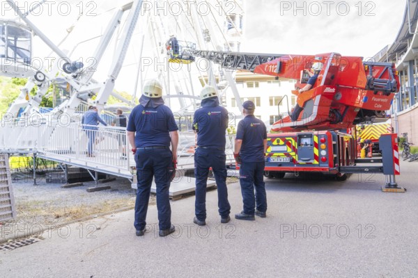 Firefighters look at an emergency situation on a Ferris wheel with a lifting platform, Fire brigade