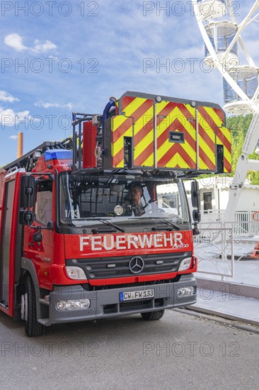 Fire engine with lifting mechanism parked in an urban environment, fire brigade exercise for