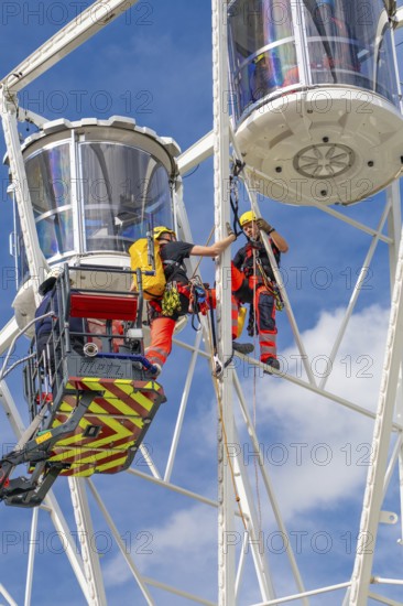Firefighters on a rescue mission high up on a Ferris wheel, Fire brigade exercise for gondola