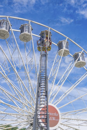 Emergency crew on lifting platform on the Ferris wheel near the gondolas, fire brigade exercise for