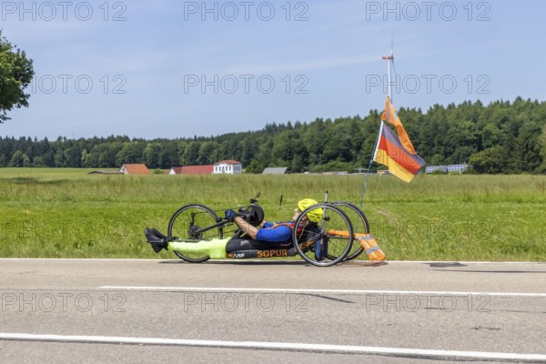 Man with handbike travelling on a country road. Special bike with manual drive for disabled people.