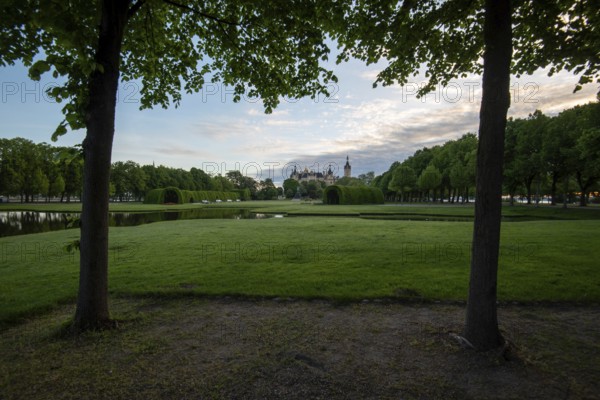 Schwerin Castle in the distance, framed by the symmetrical rows of trees in the castle garden,