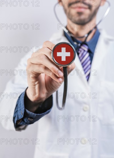 Female doctor holding stethoscope with Switzerland flag. National health system of Switzerland