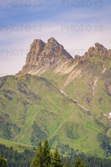 Massive mountain peaks with green slopes and minute skies over the landscape, hike to the Schlehrn,