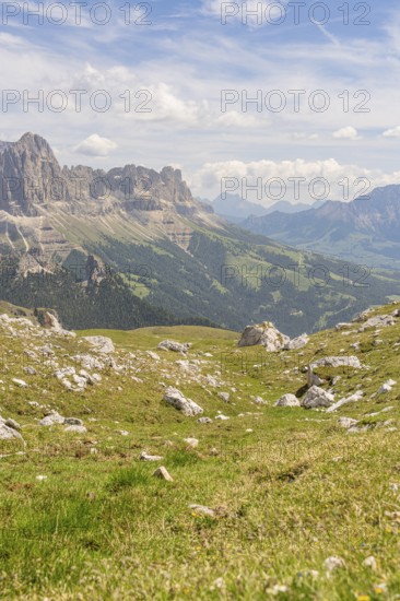 Green hills and mountains under a blue sky with soft clouds, hike to the Schlehrn, Alpe di Siusi,