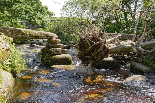 Remains of an old stone bridge and the new bridge on the East Dart River in Dartmoor National Park.