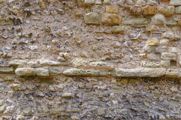 Masonry of the historic castle wall of Pevensey Castle, a Norman castle, in the village of